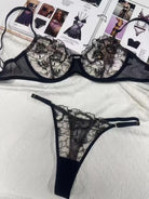 Back of black embroidered mesh lingerie set with elegant gold thread pattern adding high-end appeal.